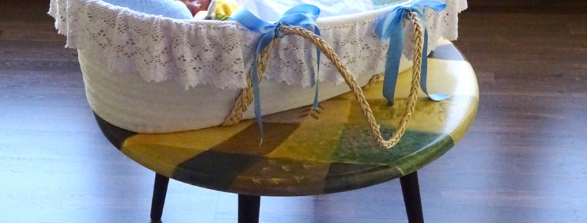 baby asleep in basket on coffee table